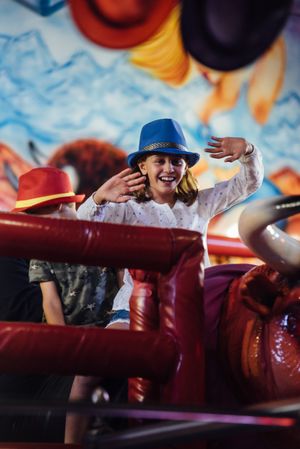 Cheerful girl riding mechanical bull