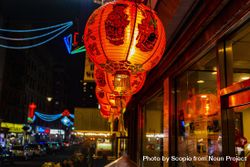 Lit red lanterns hanging beside window in the city at night 0P2YN4