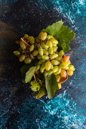 Box of fresh green grapes on blue kitchen counter