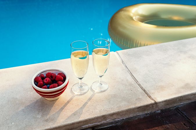 Champagne and fresh berries by the pool with an inflatable ring, for a summer party