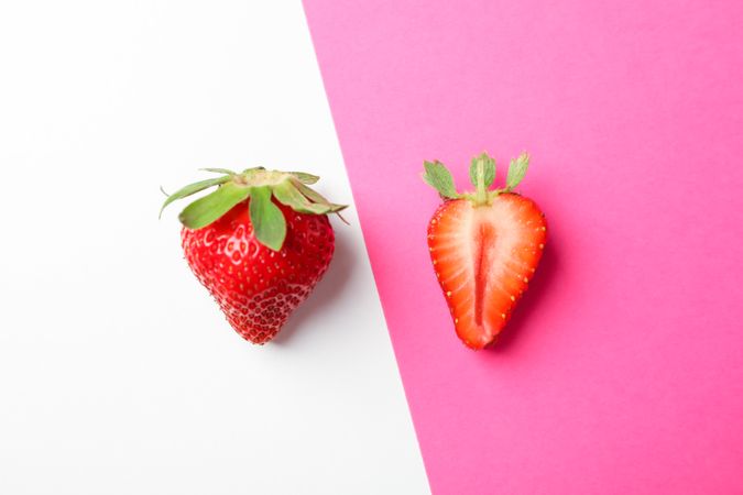 Strawberries on two color background, space for text. Summer sweet fruits and berries