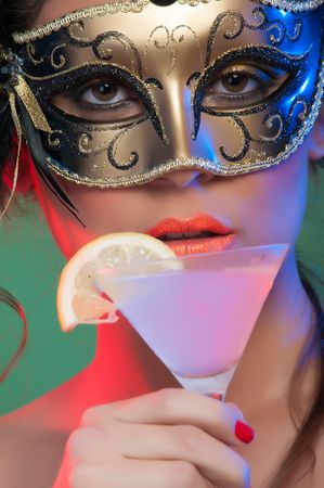 Woman in mask holding glass of drink