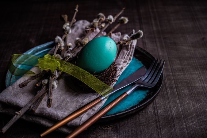 Easter table setting with blue eggs in nest and pussy willow