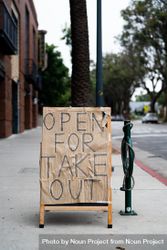 Sign on city sidewalk posted by restaurant indicating take out food available 41lgN5