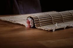 Male shushi man hands preparing different pieces of makis