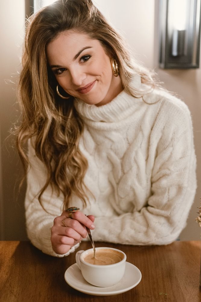 Elegant woman mixing coffee in cafe