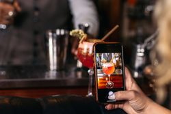 Unrecognizable person taking photos of a cocktail