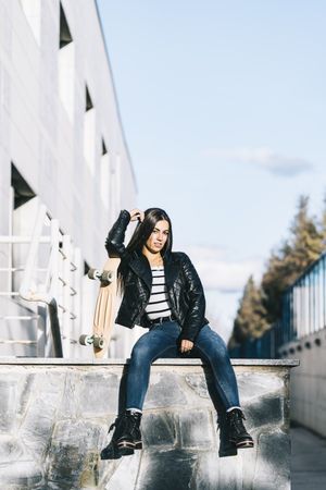 Young woman posing with skateboard