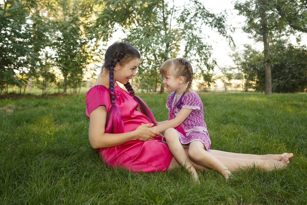 Mother and girl sitting in city park