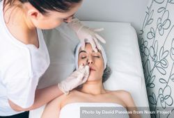 Aesthetician injecting botox between female's eye in a beauty salon 0yX8qL
