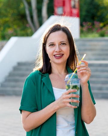 Woman drink soft drink on walk in park