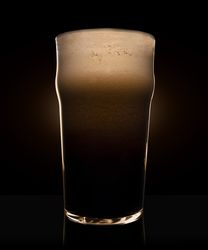 Glass of beer with heavy dark foam