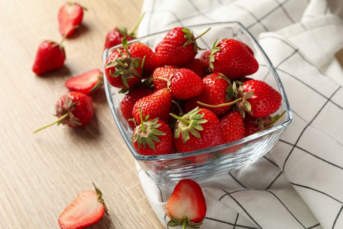 Bowl with tasty strawberry on wooden table. Summer berry