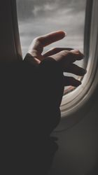 Cropped image of hand beside plane window 5rKo34