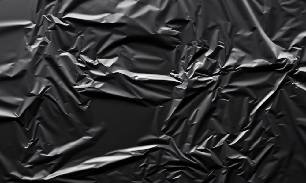dark crumpled and creased plastic poster texture background