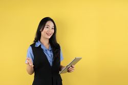 Happy Young Asian Businesswoman in Suit using Tablet Computer on Hand  for Business Presentation