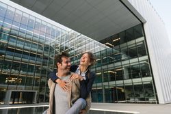 Cheerful couple having fun and hugging on street in downtown