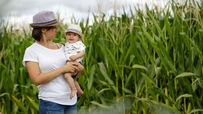 Adorable mother and child on hand enjoying and laughing in field