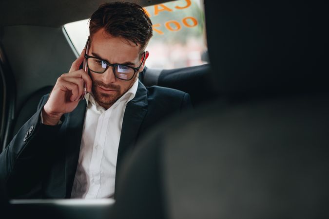 Businessman doing office work while commuting to office in a taxi