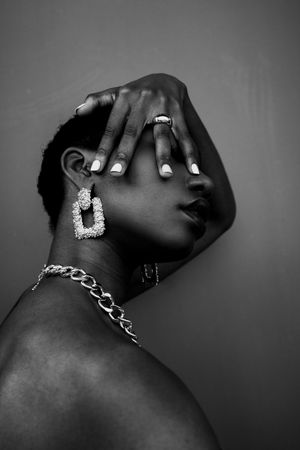 Grayscale photo of woman with gold earring and necklace