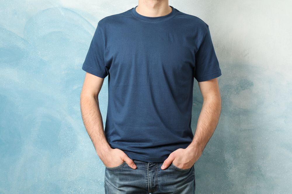 Men in blank blue t-shirt against color background, space for text