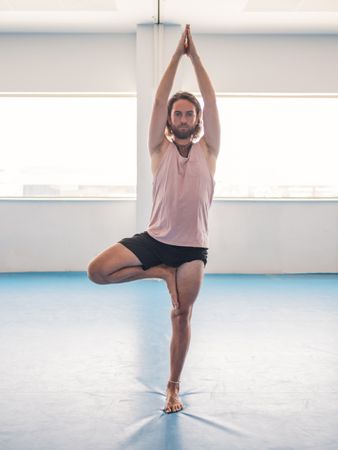 Male doing yoga in spacious room
