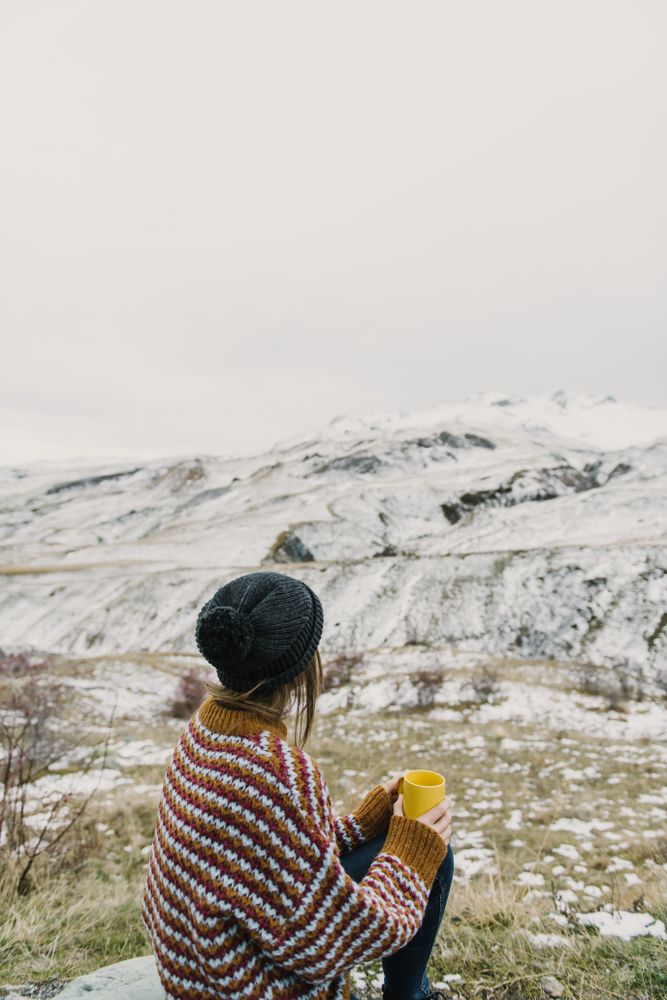 Young woman with cup between mountains