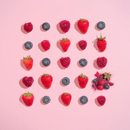 Row of multiple berries on pink background