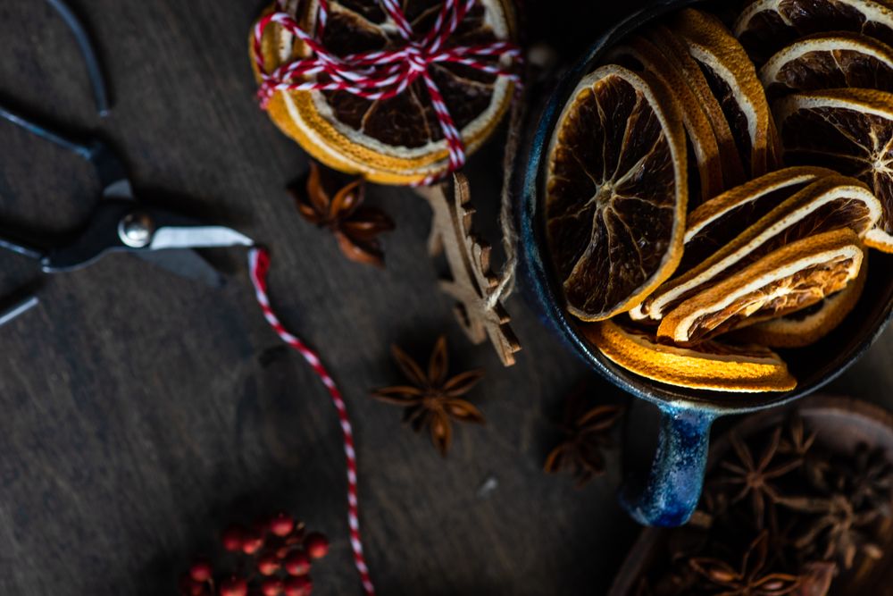 Top view of slices of dried orange in blue mug on Christmassy table
