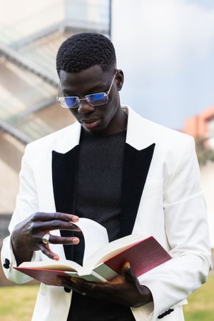 Serious Black businessman reading book in downtown