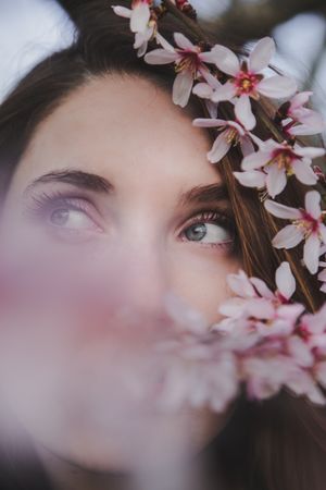 Young woman near tree twig with flowers