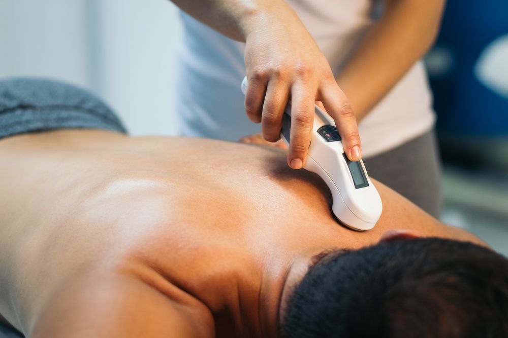 Ultrasound in Physical Therapy. Therapist Using Ultrasound Applicator on a Patient Back