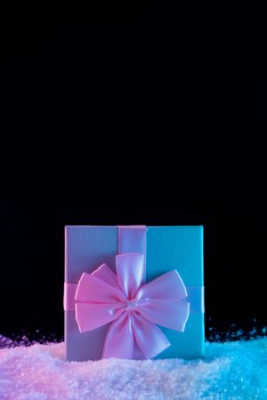 Wrapped present on vibrant bold gradient holographic colors on snow