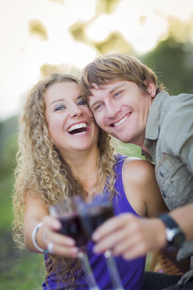 A Happy Couple With A Glass Of Wine in the Park