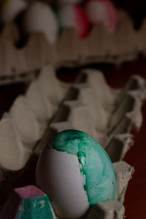 Painted Easter egg in container on table