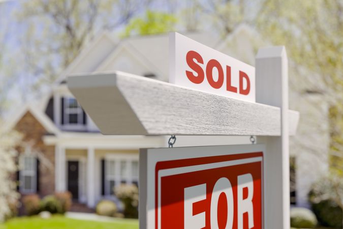 Sold For Sale Real Estate Sign in Front of Beautiful House.