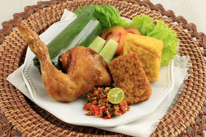 Indonesian chicken dish served with salad and tempeh