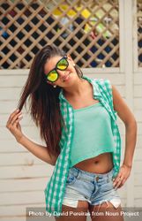 Smiling woman standing outside in jeans shorts and sunglasses 41lMGj