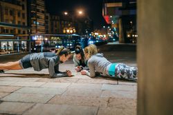 Women sport team doing planks during evening training