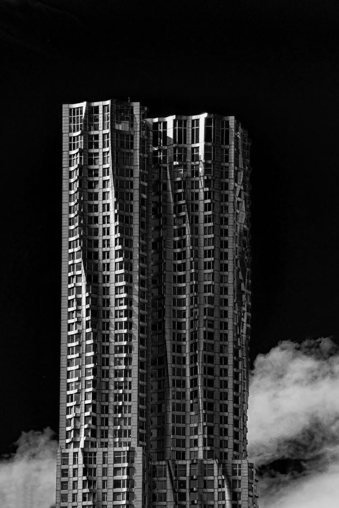 Grayscale photo of brutalist high rise building at night