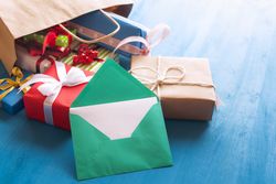 Opened envelope and bag full of colorful gifts