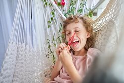 Cheerful kid licking red ice cream with pleasure