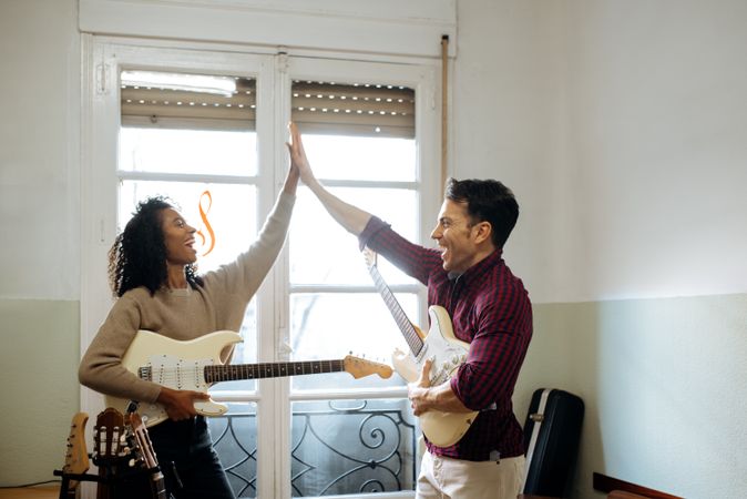 Man and woman playing guitar in studio