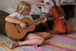 Mother and daughter playing musical instruments together at home