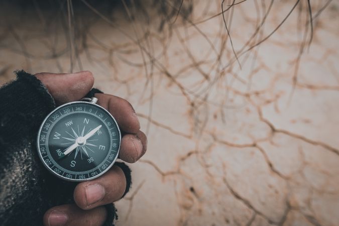 Compass in hand on dry desert area