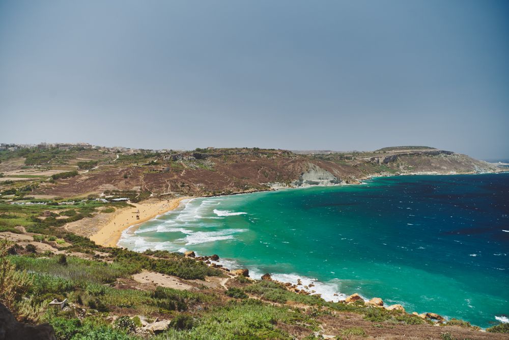 Waves coming into Maltese beach surrounded by cliffs