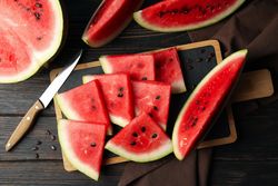 Composition with board with watermelon slices on wooden table