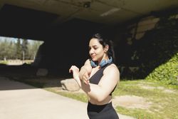 A young woman performs stretching exercises in arms and shoulders during a workout, Zaragoza, Spain