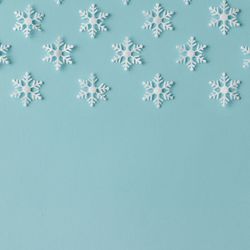 Winter pattern made of uniform snowflakes on blue background