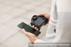 A young man transfers photos from his camera to his smartphone 5lVV7e